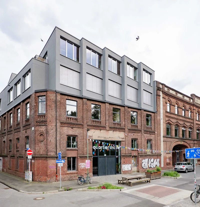 Außenansicht der KoFabrik mit Backsteinfassade und modernem Aufbau