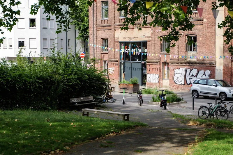 Bäume, Grünfläche und Sitzgelegenheiten auf dem Imbuschplatz vor der KoFabrik